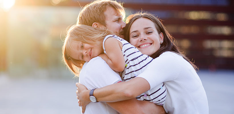 gentle dental care for the family woman embraces husband and daughter